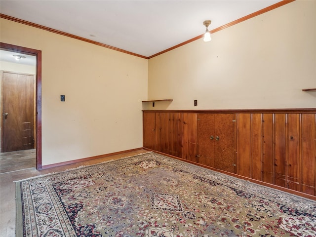 spare room with ornamental molding and wood walls