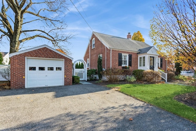 view of front of property with a garage, an outbuilding, and a front yard