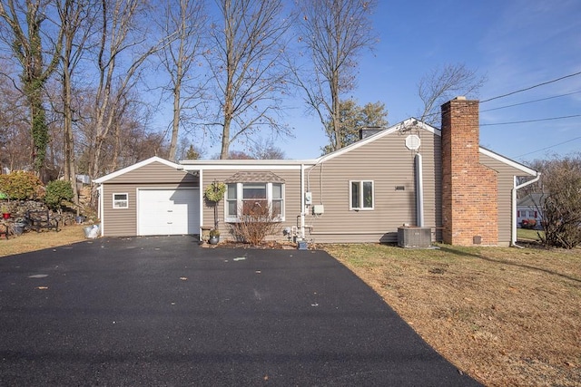 view of front of property with a garage, central AC, and a front yard