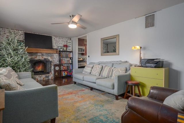 living room featuring a fireplace, hardwood / wood-style floors, and ceiling fan