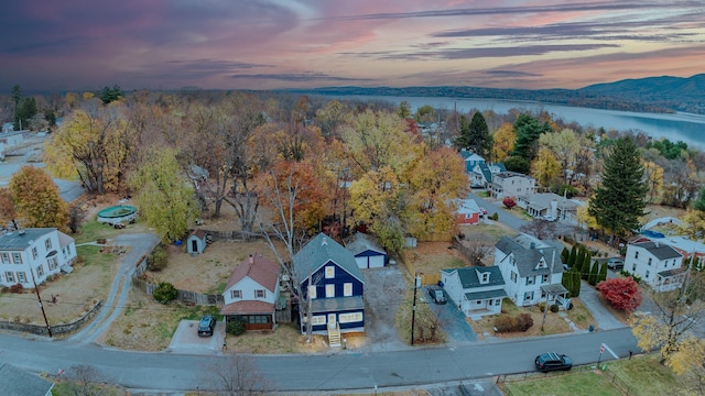 aerial view at dusk featuring a water view