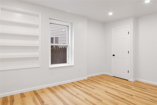 unfurnished room featuring wood-type flooring and built in features