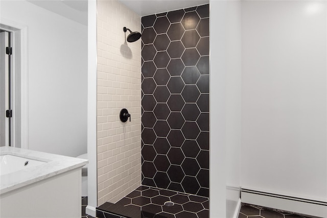 bathroom featuring a tile shower, vanity, and a baseboard radiator