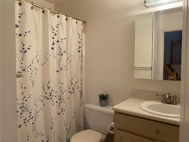 bathroom with vanity, toilet, and walk in shower