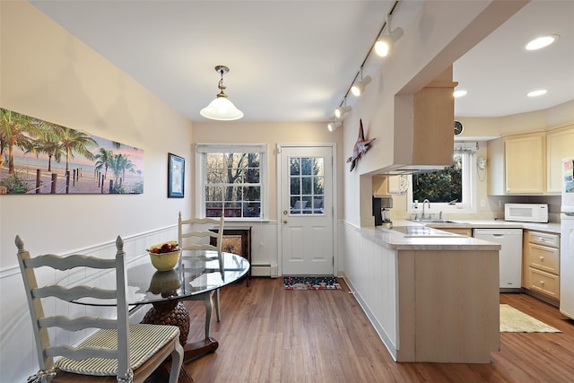 kitchen with white appliances, light countertops, baseboard heating, and wood finished floors