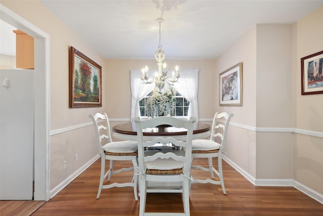 dining area with a notable chandelier, baseboards, and wood finished floors