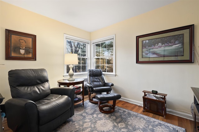 sitting room with baseboards and wood finished floors