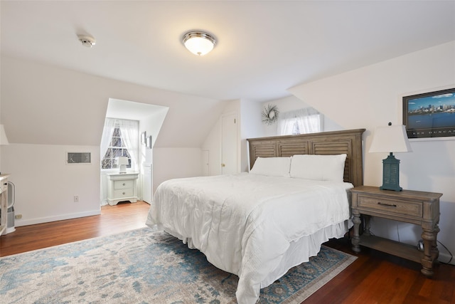 bedroom with vaulted ceiling, multiple windows, wood finished floors, and visible vents