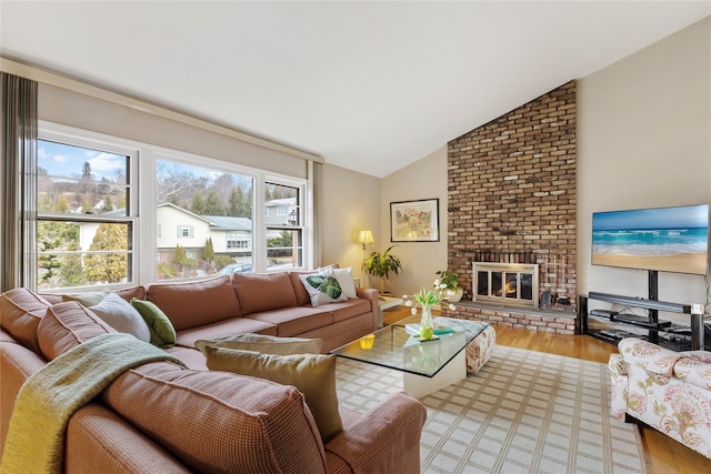 living room with a fireplace, vaulted ceiling, and wood finished floors