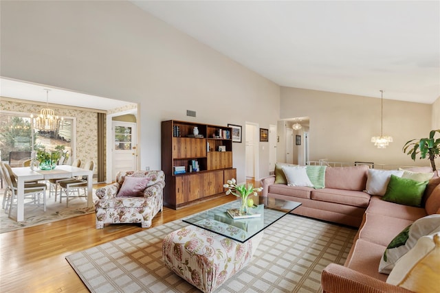 living room featuring an inviting chandelier, wood finished floors, and high vaulted ceiling