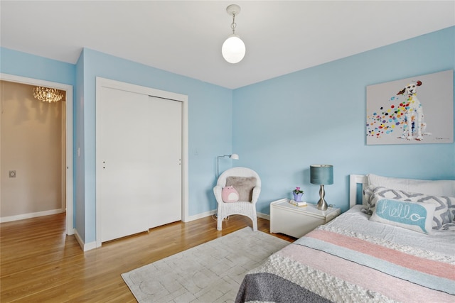 bedroom featuring a closet, baseboards, and wood finished floors