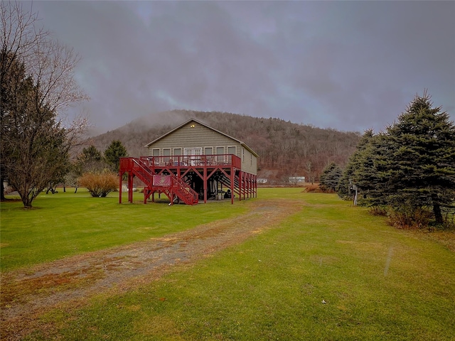 exterior space featuring a yard and a deck with mountain view