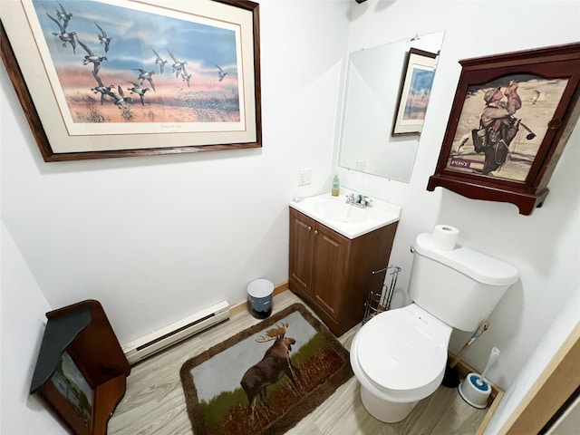 bathroom with hardwood / wood-style flooring, vanity, toilet, and baseboard heating