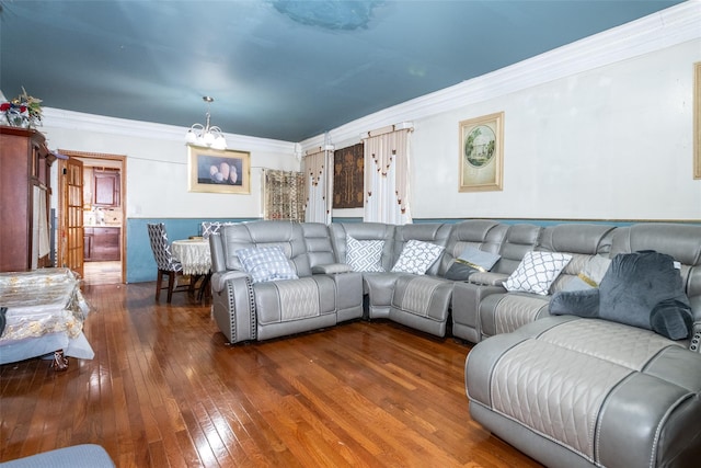 living room featuring crown molding, dark hardwood / wood-style flooring, and an inviting chandelier