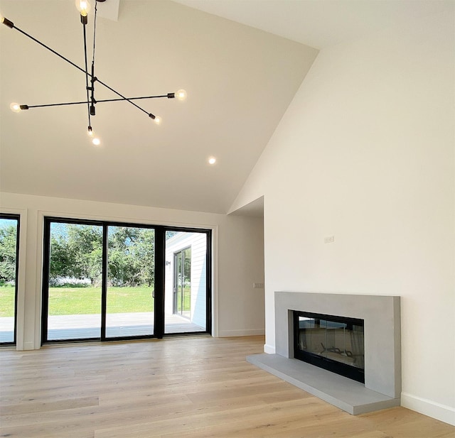 unfurnished living room with light hardwood / wood-style flooring, high vaulted ceiling, and a wealth of natural light