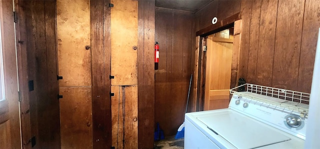 clothes washing area with washer / dryer and wooden walls