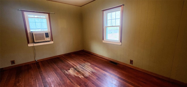 unfurnished room featuring plenty of natural light, cooling unit, and hardwood / wood-style flooring