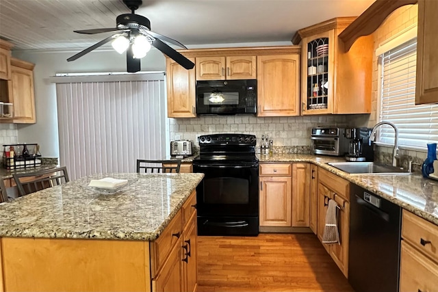 kitchen with sink, decorative backsplash, black appliances, light stone countertops, and light hardwood / wood-style flooring