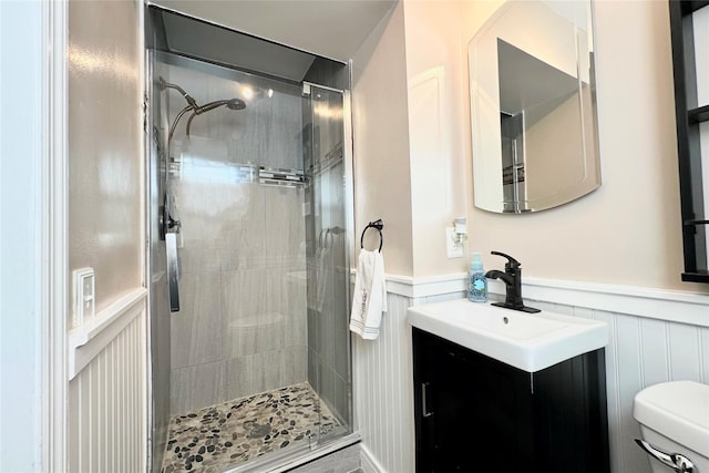 bathroom with vanity, toilet, and a tile shower