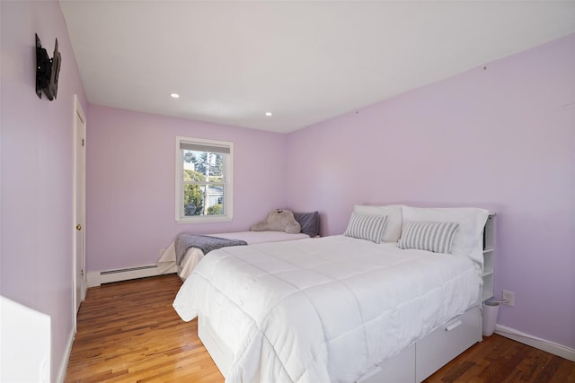 bedroom with a baseboard radiator and light hardwood / wood-style floors