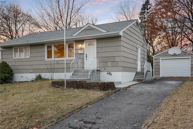 single story home with an outbuilding, a garage, driveway, roof with shingles, and a front yard