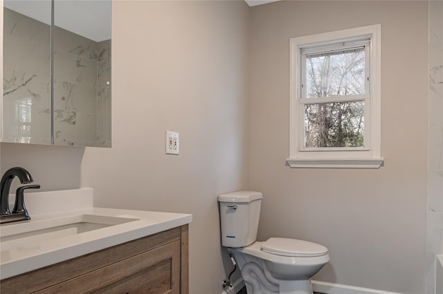 full bathroom featuring toilet, vanity, and baseboards