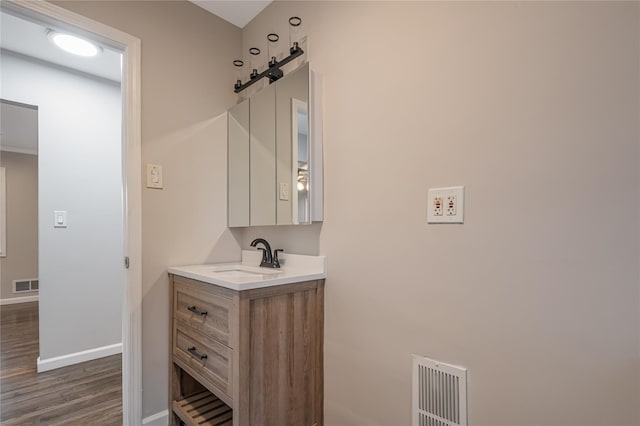 bathroom with wood finished floors, vanity, visible vents, and baseboards