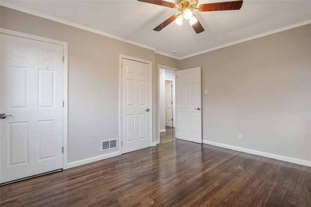 unfurnished bedroom featuring ornamental molding, visible vents, dark wood finished floors, and baseboards