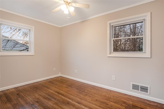 unfurnished room with dark wood-style flooring, visible vents, crown molding, and baseboards