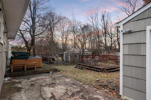 view of yard with a patio, a shed, a wooden deck, and a hot tub