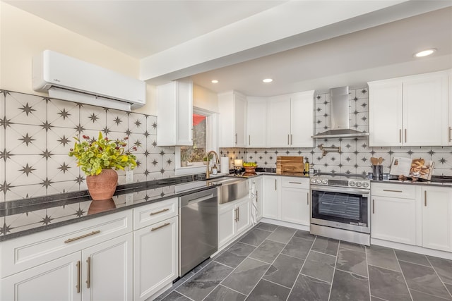 kitchen with wall chimney exhaust hood, a wall unit AC, backsplash, white cabinets, and appliances with stainless steel finishes