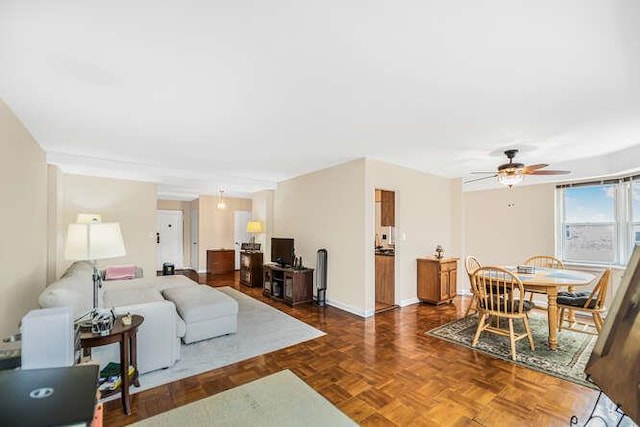 living room featuring dark parquet flooring and ceiling fan