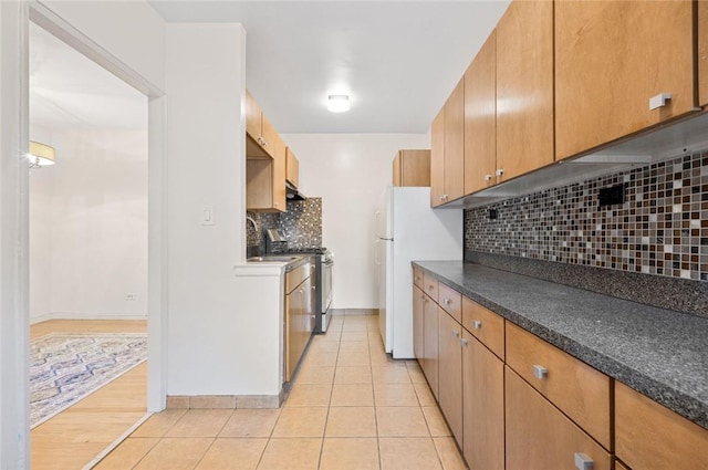 kitchen featuring electric range, decorative backsplash, white refrigerator, and light wood-type flooring