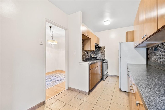 kitchen featuring pendant lighting, sink, decorative backsplash, light tile patterned floors, and stainless steel range