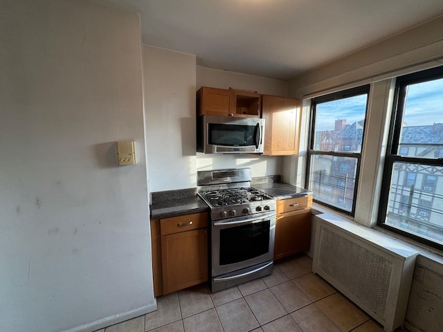 42 Pondfield Rd W Unit 6C, Bronxville, NY 10708 - kitchen with stainless steel appliances, radiator heating unit, light tile patterned floors, dark countertops, and open shelves