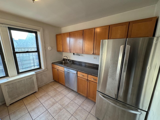 kitchen with radiator, light tile patterned floors, sink, and appliances with stainless steel finishes