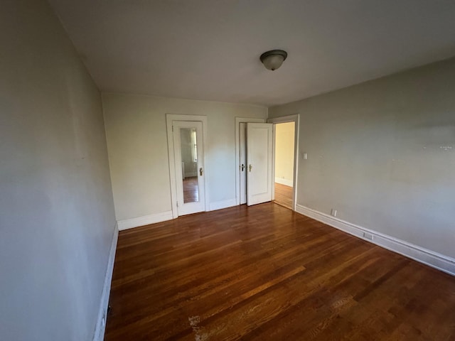 unfurnished bedroom with dark hardwood / wood-style flooring