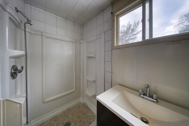 bathroom with tile patterned flooring, vanity, and a shower