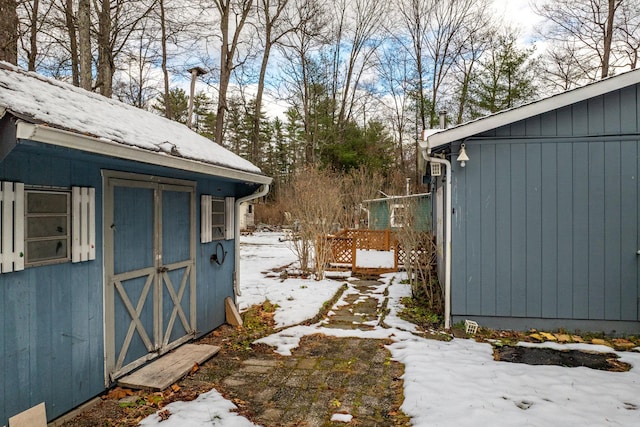 yard layered in snow with a shed