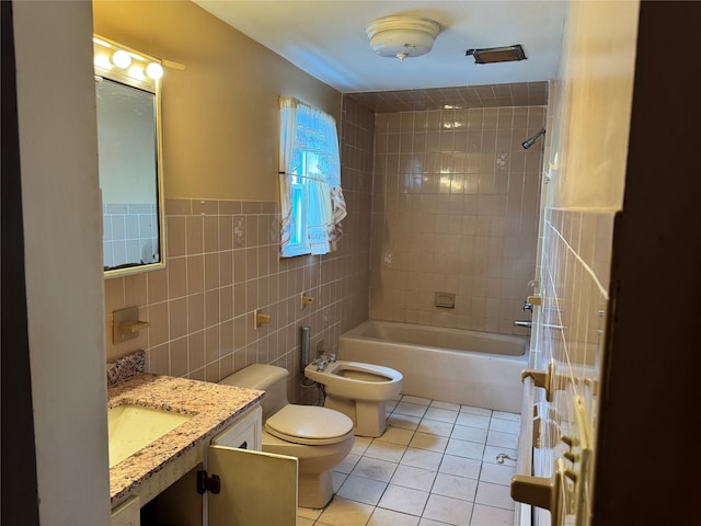 full bathroom featuring a bidet, tile walls, tile patterned flooring, vanity, and toilet