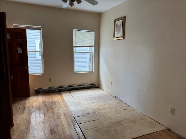 empty room with ceiling fan, a baseboard heating unit, and light wood-type flooring