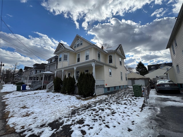 view of snowy exterior featuring covered porch