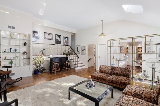 living room featuring dark wood-type flooring and lofted ceiling with skylight