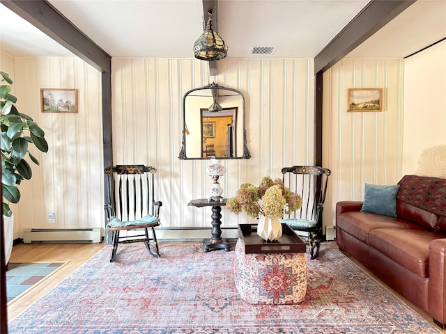 sitting room with beam ceiling, a baseboard radiator, and wood-type flooring