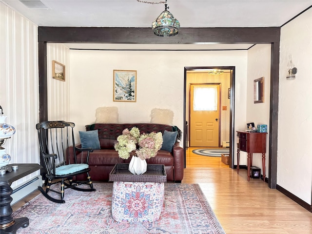 living room featuring light hardwood / wood-style floors and a baseboard heating unit