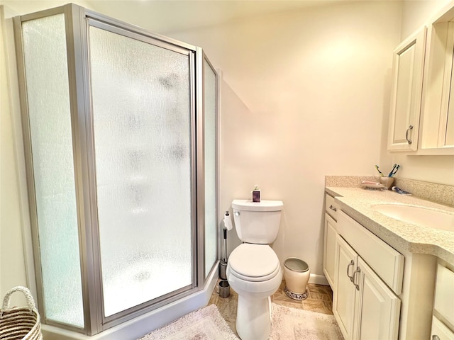 bathroom with toilet, a shower with shower door, and vanity