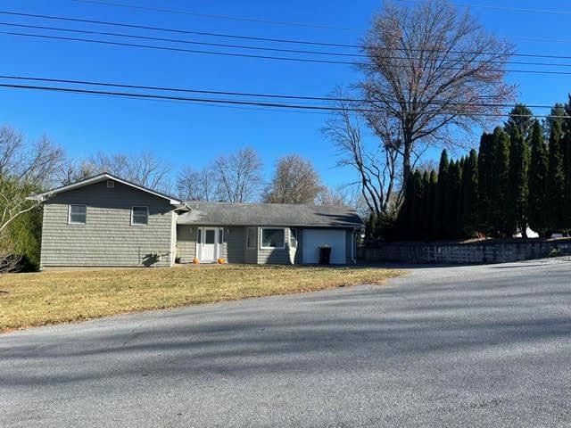 single story home with a garage and a front yard