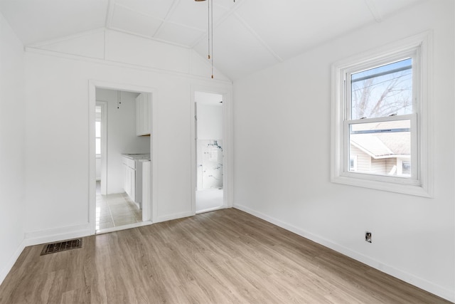 spare room with ceiling fan, light hardwood / wood-style floors, and vaulted ceiling