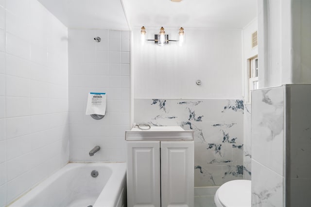 bathroom with sink, toilet, and tile walls