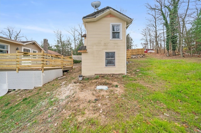 view of side of home featuring a wooden deck and a yard